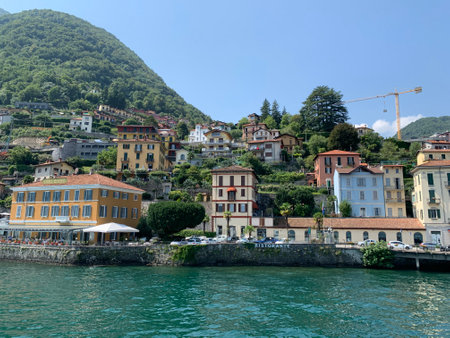 Skyline of Argegno town with houses on hills and mountains. Landscape of Como Lake (Lago di Como). View from the boat of cityscape and nature. Argegno, Como Lake, Lombardyのeditorial素材