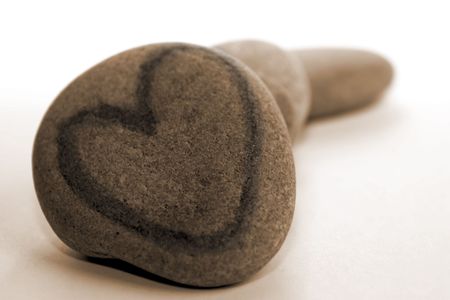 Heartshaped stone isolated on white, sepiaの写真素材