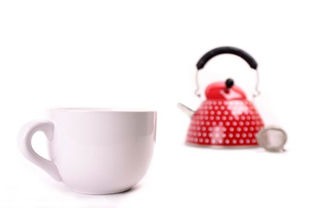 Cup in the front of a red teapotの写真素材