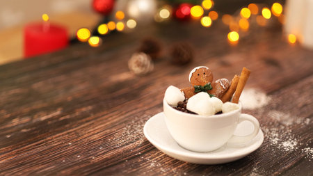 Cup of hot chocolate with marshmallows and gingerbread man on wooden tableの写真素材