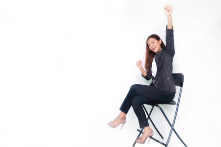Happy business woman sitting on chair with white background and copy space.の写真素材