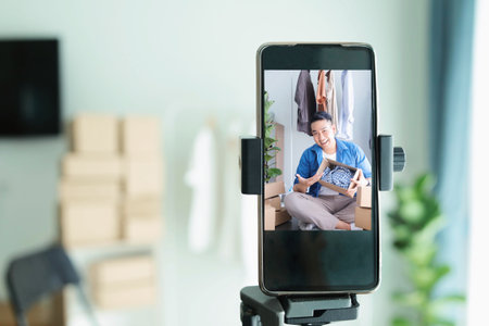 woman using smart phone to take a photo of her home with boxes
