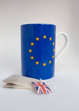 Cup with european flag and teabag with British flag, isolated on white backgroundの写真素材