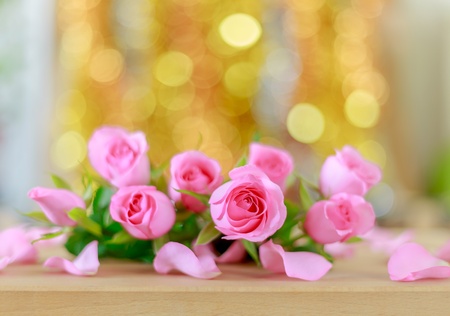 Pink roses on bright golden bokeh backgroundの素材