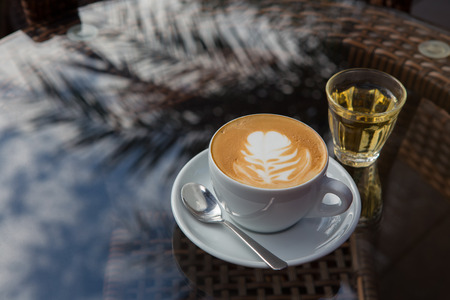 a cup of hot coffee on the glass tableの写真素材