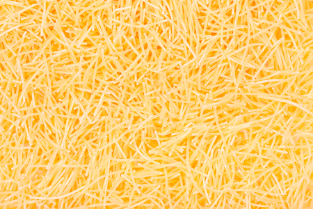 Pasta noodles background close up top view.