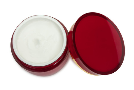 Red glossy round box container and cover with cosmetic cream. Isolated on a white background, close-up, top view.の写真素材