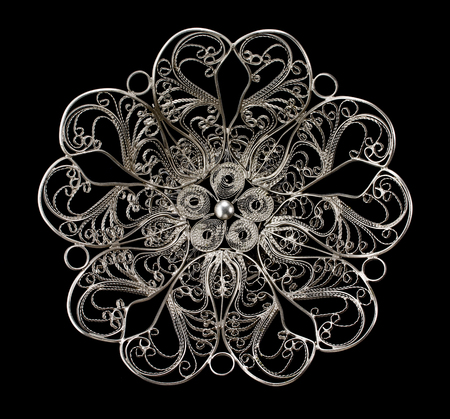 Vintage silverware, metal lace candy vase isolated on a black background, top view.