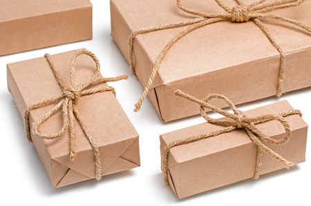 Parcels wrapped, gift boxes with brown kraft paper and tied with twine and bows. Isolated on white...