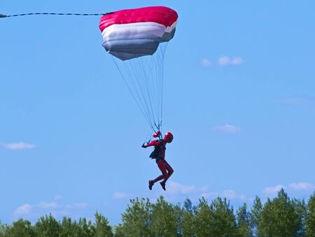 Landing of a skydiver with colorful parachute.の写真素材