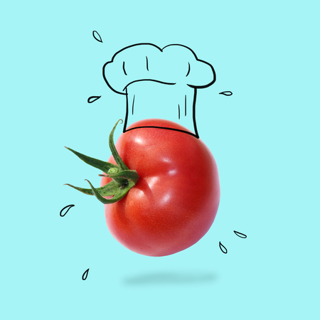 Chef hat with tomato concept on pastel blue background. minimal idea food and fruit creative concept.の写真素材