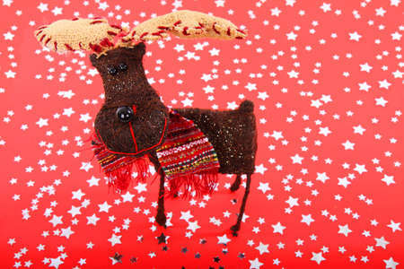Smiling reindeer on red background with silver starsの写真素材