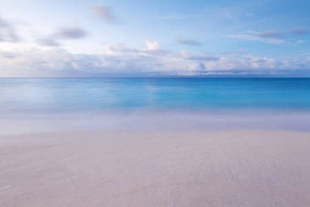 beach with blurred waves and sky in the morningの写真素材