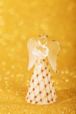 christmas angel decoration on a yellow golden backgroundの写真素材