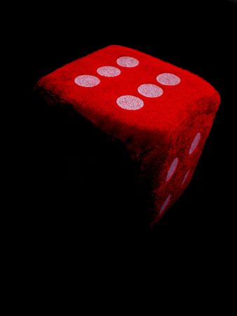 one red die isolated on black の写真素材