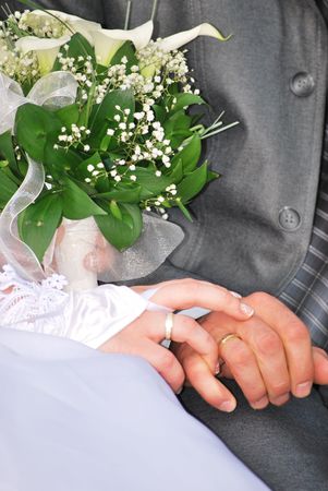 married couple holding hands with bridal wedding bouquetの写真素材