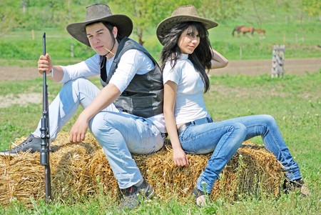 young couple in love sitting on a hay baleの写真素材