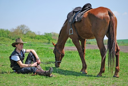 young and attractive man riding brown horseの写真素材