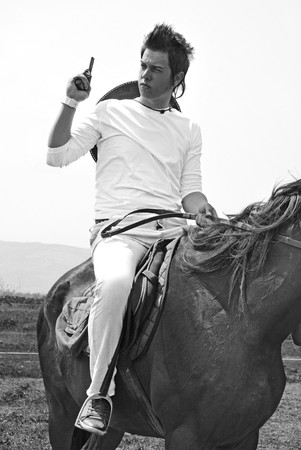 young and attractive man riding brown horseの写真素材