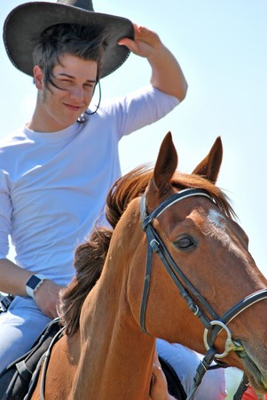 young and attractive man riding brown horseの写真素材