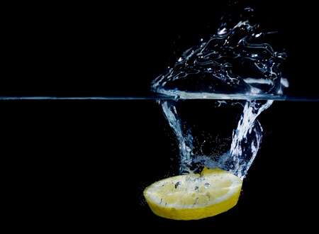 lemon splashing in pure water isolated on black backgroundの写真素材