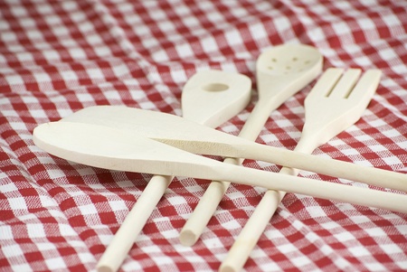 Wooden kitchen utensils over red and white cloth fabricの写真素材