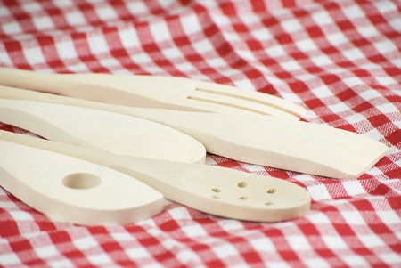 Wooden kitchen utensils over red and white cloth fabricの写真素材