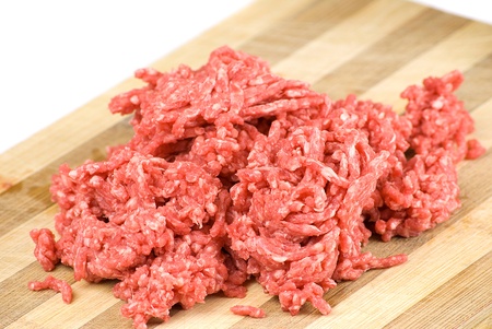 pile of fresh raw beef mince over wooden kitchen board