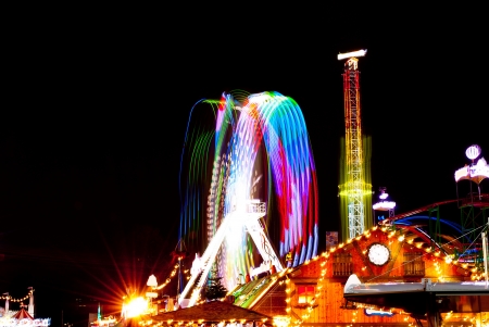 long exposure pictures of amusement park rides and wheels at nightのeditorial素材