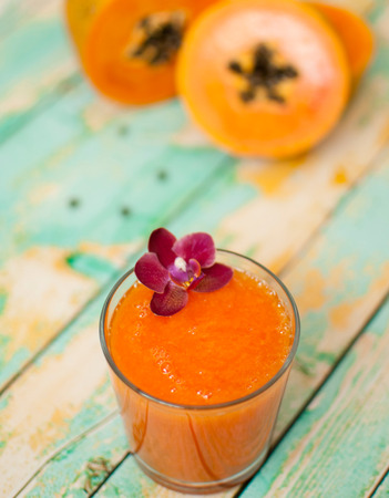 healthy fresh papaya smootie juice on wooden green boardsの写真素材