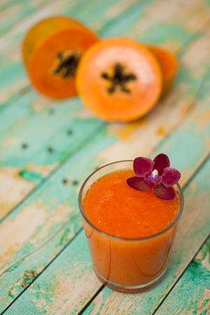 healthy fresh papaya smootie juice on wooden green boardsの写真素材