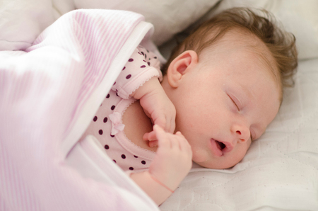 beautiful newborn baby girl sleeping peacefullyの写真素材