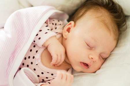 beautiful newborn baby girl sleeping peacefullyの写真素材
