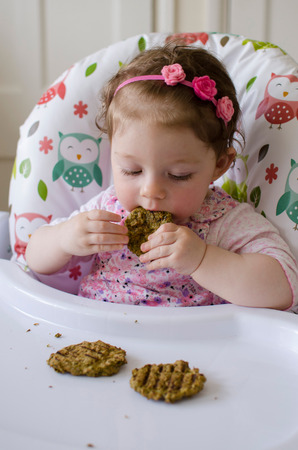 baby led weaning girl eating grilled chicken meatballs for lunchの写真素材