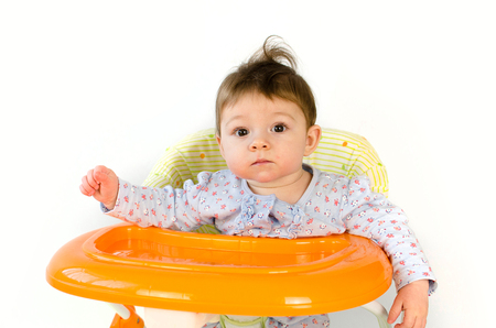 adorable happy baby girl sitting in a walkerの写真素材