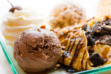 tasty pancakes with chocolate ice cream crispy waffle whipped cream with brownies cherry almond and chocolat syrup on top.served pancakes crepes on plate.sweets dessert brownies pancakes crepes.の写真素材