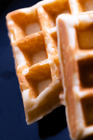 woman hands prepare waffle for serving process.waffle made from dough and batter.tasty dessert...