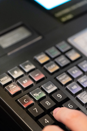cash register installed on counter for accepting order from customer.sales man entering amount on electronic cash register in coffee shop and retail store.restaurant cashier typing on cash register.の写真素材