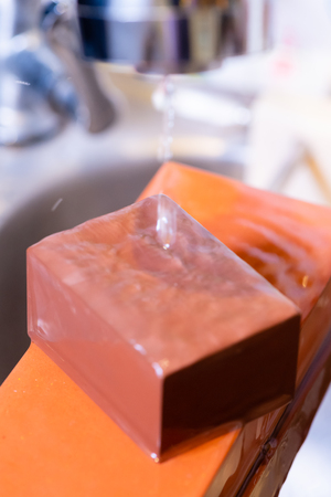 woman professional chef hands hold knife for whetting on whetstone.premium professional stone from japan.knife sharpening process with traditional sharpener stone for knife sharpen edge in restaurant.の写真素材