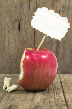 teeth against red apple on woodenの写真素材