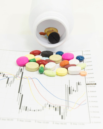 Pills spilling on stock chart - market analysisの写真素材