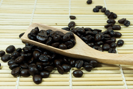 Coffee beans in wooden spoon, close up の写真素材