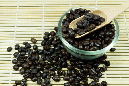 Coffee beans in wooden spoon, close upの写真素材