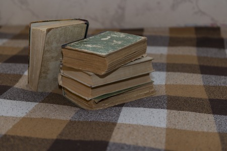 stack of battered old books on a plaidの写真素材