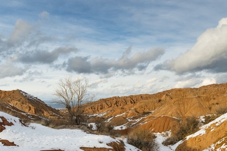 Orange hills in the snow, Kyrgyzstan, witerの写真素材