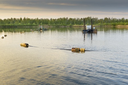 cleaning machines in the pond at sunsetの写真素材