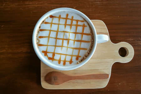 Caramel Macchiato Hot Coffee in White Cup on tableの写真素材