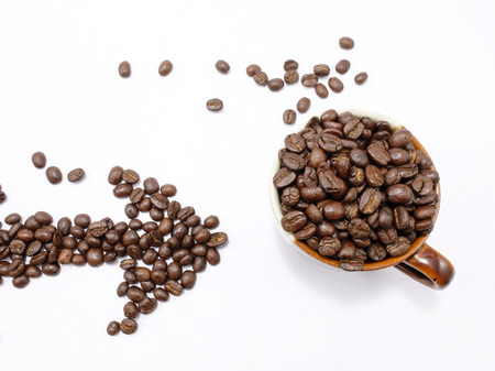 Arrow made from  coffee beans with a cup isolated on white backgroundの写真素材