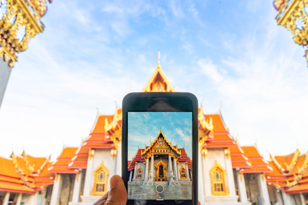 Taking photo Thai Marble Temple (Wat Benchamabophit Dusitvanaram) with mobile phone in Bangkok, Thailandの写真素材