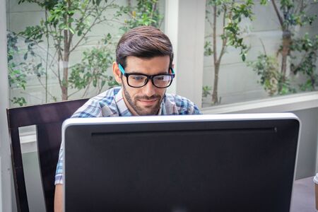 Good looking young business man working on the internet at home